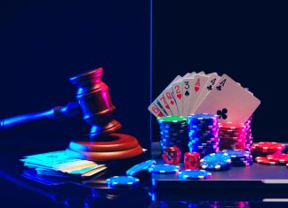 A gavel, handcuffs, playing cards, and player gambling chips are arranged against a dark blue background with neon lights.