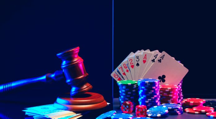 How Europe’s Patchwork of Gambling Laws Shapes Your Online Casino Experience A gavel, handcuffs, playing cards, and player gambling chips are arranged against a dark blue background with neon lights.