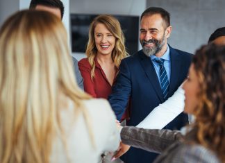 3 Things a ‘Bento Box’ Approach Can Teach Leaders about Building a Culture of Care A diverse business team smiling and joining hands in a show of unity, care and teamwork.