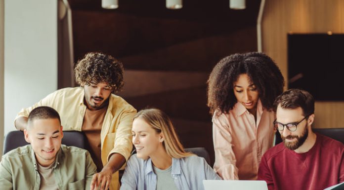 Diverse team of young Gen Z professionals collaborating on a project in a modern office