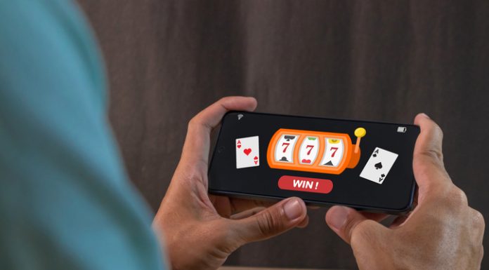 Man winning jackpot on online casino app on a smartphone. Online casino gambling development concept.