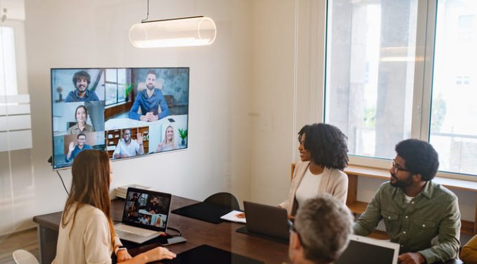 Business professionals actively discussing ideas and strategies during a hybrid corporate meeting.