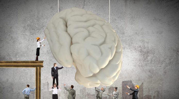 Huge human brain and many little businesspeople around. Concept of thinking new ideas