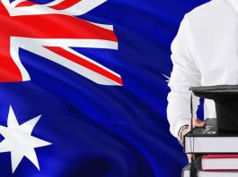 Holding books and graduation cap over Australia flag