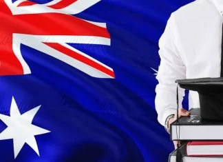 Holding books and graduation cap over Australia flag