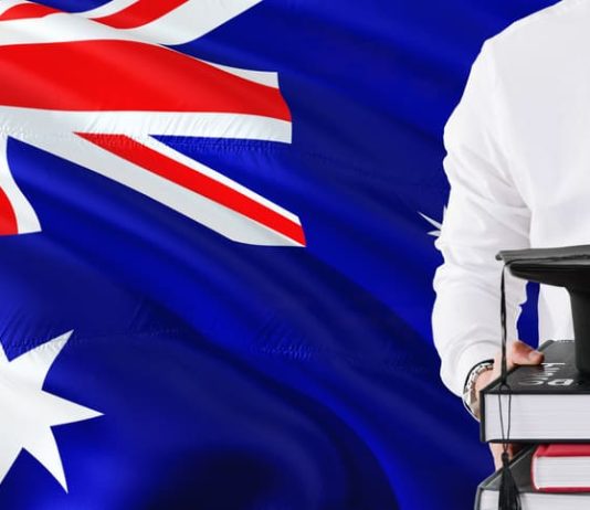 Why More Students are Choosing to Pursue their MBA in Australia Holding books and graduation cap over Australia flag