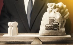 Businessman balancing Money over people