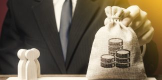 Businessman balancing Money over people