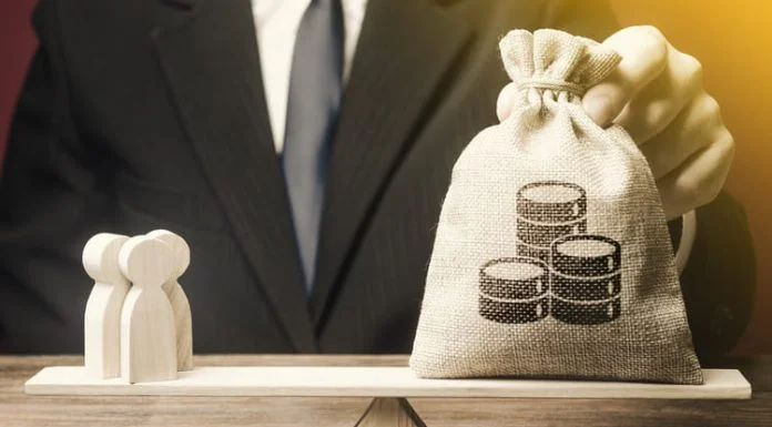 Businessman balancing Money over people