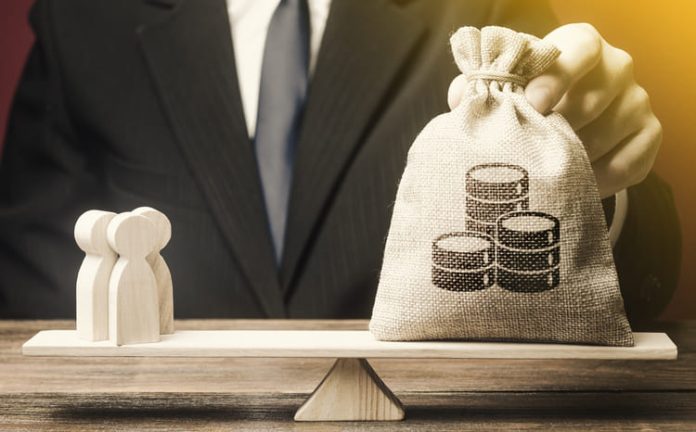 Businessman balancing Money over people