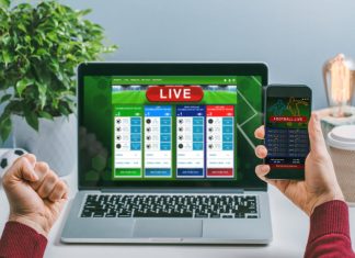 Man using his laptop and smartphone for making research on bets online at bookmaker's website and mobile application.