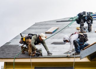 Crew Installing New Shingles on Roof on a Rainy Day