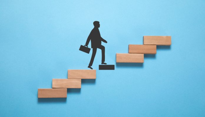Businessman climbing on career ladder made by wooden block. Personal development. Career growth Businessman climbing on career ladder made by wooden block.