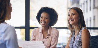 Business Team Meet Around Boardroom Table With Laptops Discussing services and documents