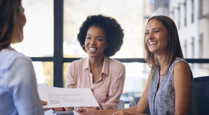 Business Team Meet Around Boardroom Table With Laptops Discussing services and documents