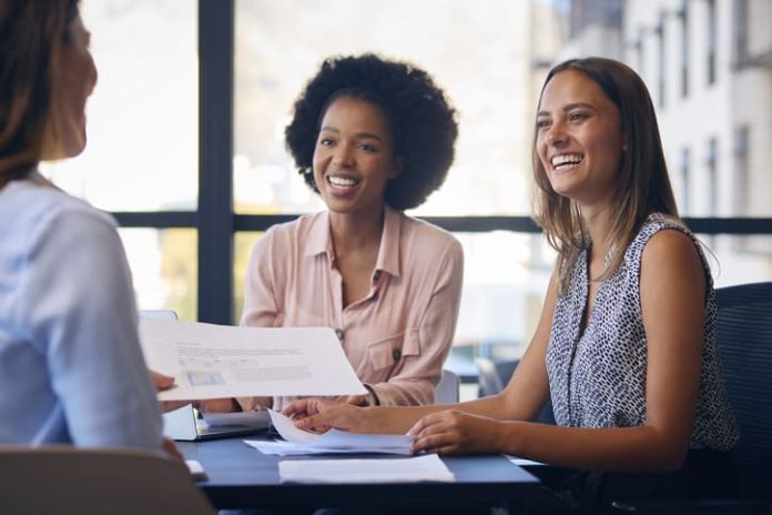 Business Team Meet Around Boardroom Table With Laptops Discussing services and documents