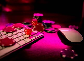 Online casino. Online poker. On the table there are game pieces and dice next to the keyboard