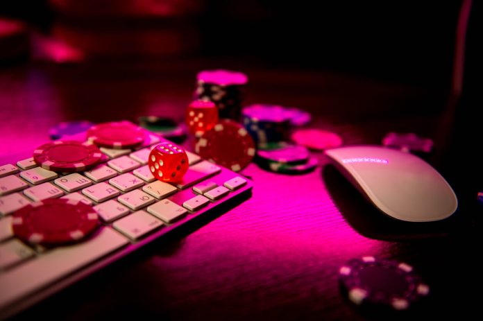 Online casino. Online poker. On the table there are game pieces and dice next to the keyboard