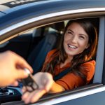 businesswoman receiving keys of her rental car