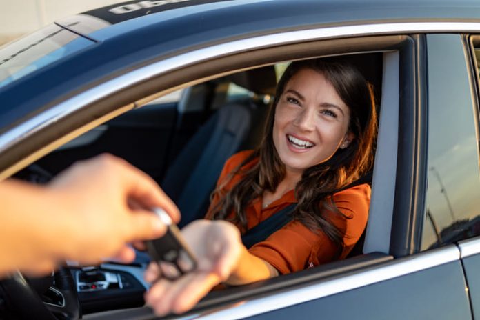 businesswoman receiving keys of her rental car
