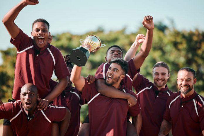 Cricket players celebrating, cheering and holding trophy at competition.