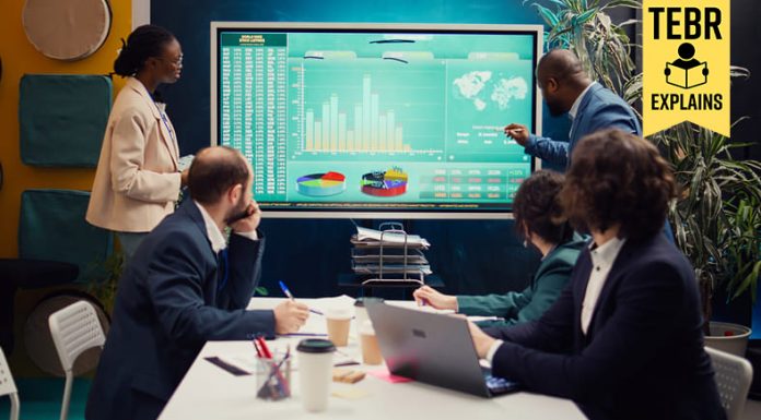 Startup team analyzing worldwide sales, shares and client feedback, using interactive boar to examine revenue and funds.