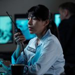 How to Set Up a Security Company in the UK Security officer of surveillance room reporting situation on walkie-talkie while looking at computer screen