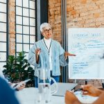 leader of the leaders presenting a strategy on leadership skills to engaged, diverse colleagues in a fresh and innovative office setting.