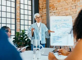 The Future-Fit Leader: The Four Essential Skills You Need Now leader of the leaders presenting a strategy on leadership skills to engaged, diverse colleagues in a fresh and innovative office setting.