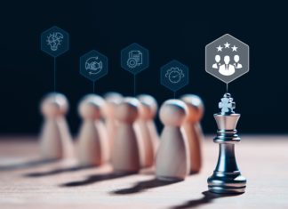 The Trouble With Meritocracy Chess king stands with wooden figures and leadership icons, representing the concept of effective leadership, meritocracy, highlights the importance of strategy, competition and intelligence in achieving success