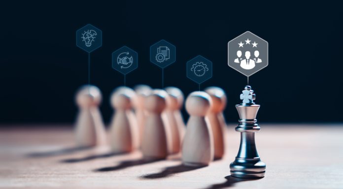 Chess king stands with wooden figures and leadership icons, representing the concept of effective leadership, meritocracy, highlights the importance of strategy, competition and intelligence in achieving success