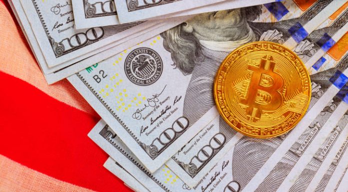 American dollars cash bills, gold Bitcoin token are arranged attractively on US flag fabric