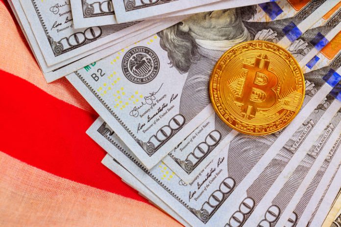 American dollars cash bills, gold Bitcoin token are arranged attractively on US flag fabric