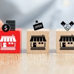 Could a Missed Clause Jeopardize Your Franchise? Close-up hand choose cube wooden toy blocks place in line up with franchise business store icon. Clause in Franchising