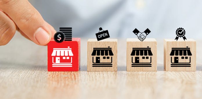 Close-up hand choose cube wooden toy blocks place in line up with franchise business store icon. Clause in Franchising