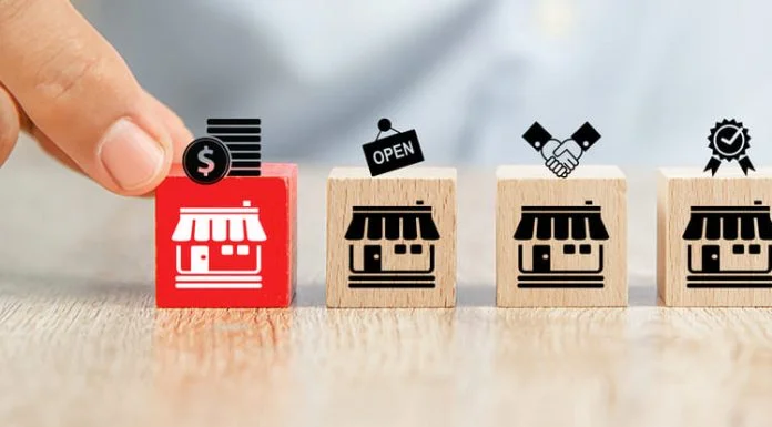 Close-up hand choose cube wooden toy blocks place in line up with franchise business store icon. Clause in Franchising