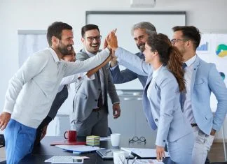Motivation Myths: Why Carrots and Sticks are Failing Your Team Successful businesspeople expressing motivation towards work.