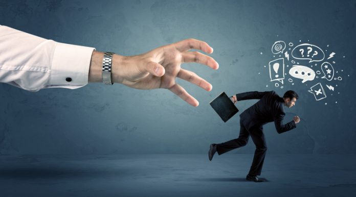 Business man with doodle icons running from a big hand concept on background