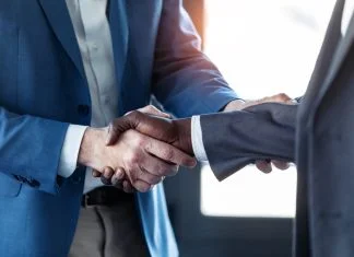 Close-up view of business partner handshaking for hybrid support teams