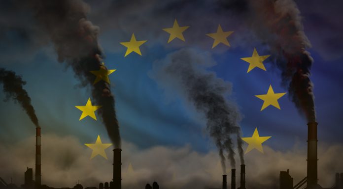 dense smoke from industry pipes for decarbonization on European Union flag