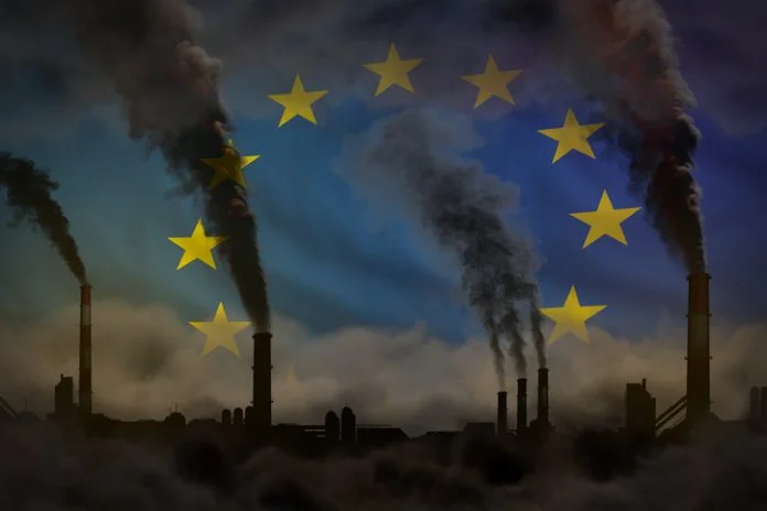 dense smoke from industry pipes for decarbonization on European Union flag
