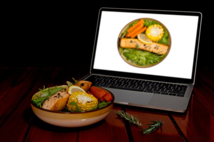 Grilled Salmon Salad, Lettuce, Grilled Corn, Carrot, Lemon, Rosemary. Find or learning cooking recipes from computer laptop via internet. Seafood brand editing on computer