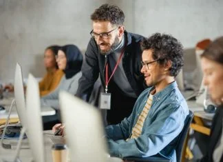 Teacher Giving Lesson to Diverse Multiethnic Group of Female and Male Students in College Room, Teaching New Academic Skills on a Computer in Germany