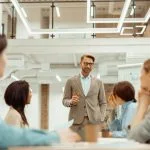 Man standing in office and storytelling and explaining new ideas to colleague