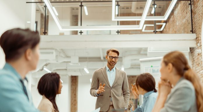 Man standing in office and storytelling and explaining new ideas to colleague