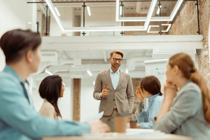 Man standing in office and storytelling and explaining new ideas to colleague