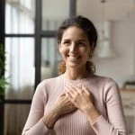 Hispanic woman put folded palms on chest feels gratitude