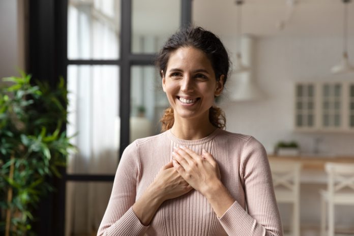 Hispanic woman put folded palms on chest feels gratitude