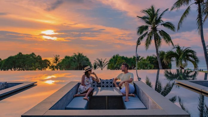 Couple watching sunset in infinity pool on a luxury space during vacation