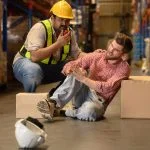 Worker handling large cardboard boxes then some of the box falling and hit by accident